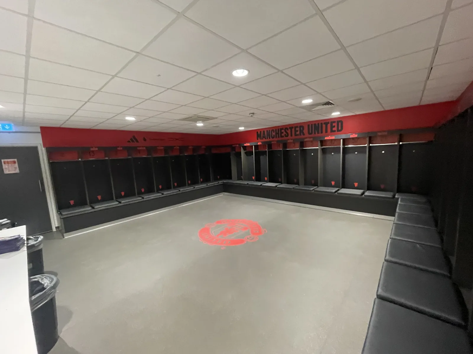 Red wall vinyl running around the top of a dressing room, with a circular floor graphic at its centre
