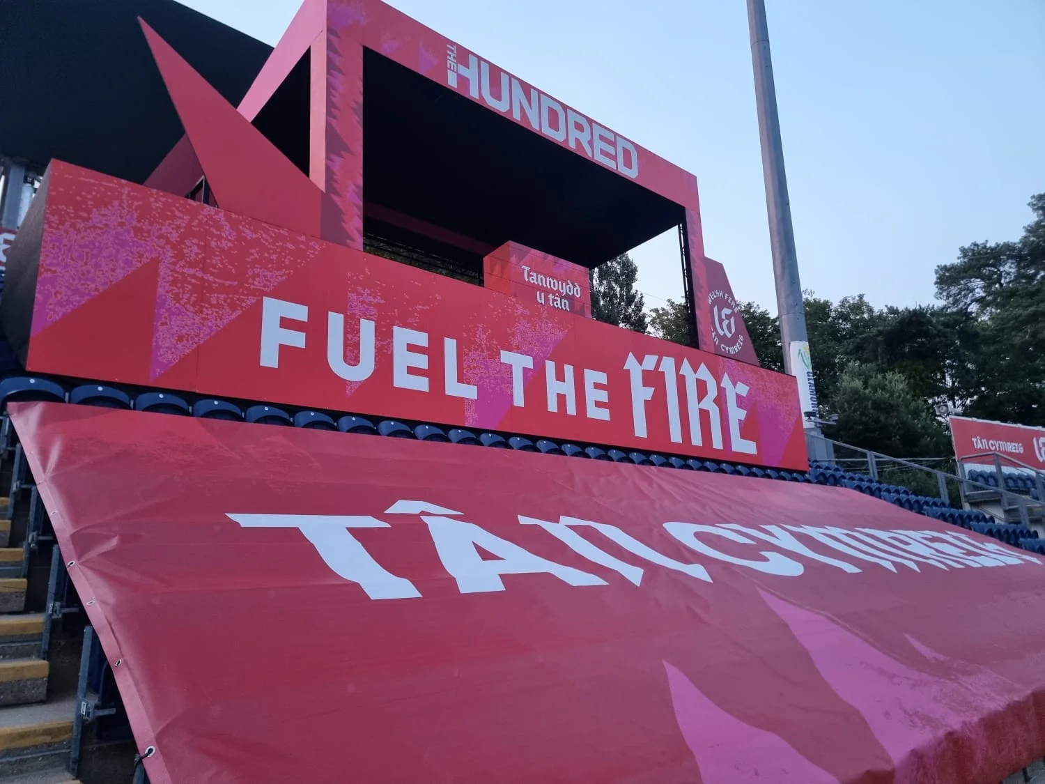 Fully wrapped event stage and branded seating decks in a stadium stand